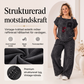 Damtopp med axelbandslös design och vida byxor